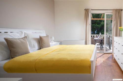 a yellow bed in a white room with a table at Sonia Hvar in Rudina