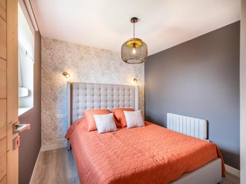 1 dormitorio con 1 cama con colcha de color naranja en Cottage B10 en Koksijde