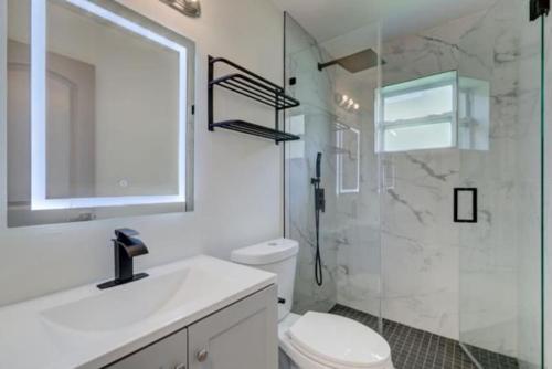 a bathroom with a toilet and a sink and a shower at SuaveMauve Las Olas Beach in Fort Lauderdale