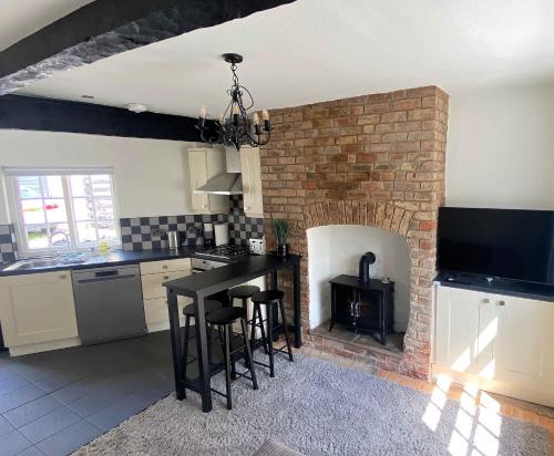 a kitchen with a brick fireplace with a table and chairs at 2 Bed House in Knaresborough in Knaresborough