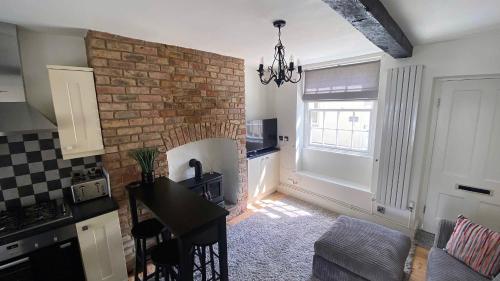 uma cozinha com uma parede de tijolos e uma sala de jantar em 2 Bed House in Knaresborough em Knaresborough