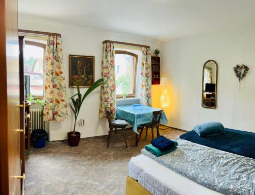 1 dormitorio con cama, mesa y ventana en Apartment Amelie - Zimmer mit TV, W-Lan, Mikrowelle und Kühlschrank, Bad mit Dusche, en Malterdingen