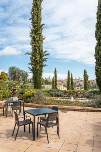 a patio with tables and chairs and a garden at Cigarral de Caravantes in Toledo