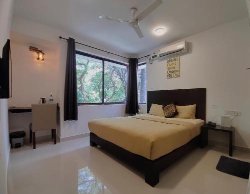 um quarto com uma cama grande e uma janela em The Royal Living I Indiranagar em Bangalore