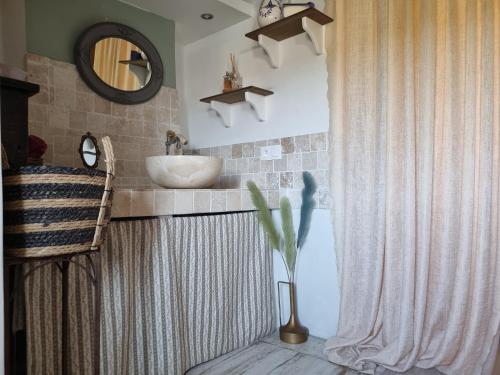 y baño con lavabo y espejo. en Maison ancienne romantique avec terrasse panoramique, en Vaison-la-Romaine
