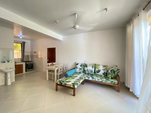 a living room with a couch and a kitchen at Silent Palms Villa in Galu