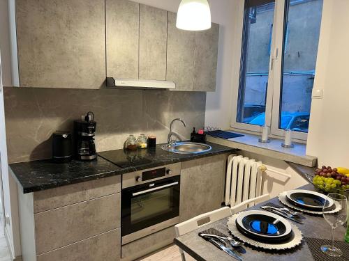 a kitchen with a sink and a stove top oven at Apartamenty KoktajLOVE in Kielce