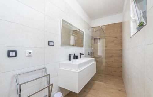 ein weißes Badezimmer mit einem Waschbecken und einem Spiegel in der Unterkunft Elite 1 in Pula