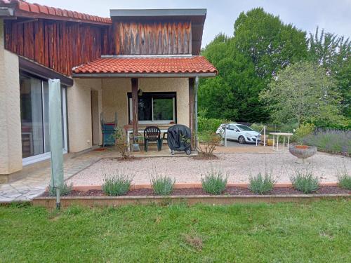 a house with a patio with a table and chairs at Gîte A-B Roger in Ganties
