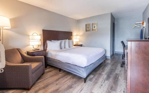 um quarto de hotel com uma cama e uma cadeira em Butler Inn em Oxford