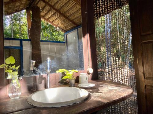 a bathroom with a sink and a window at Bangalô Ponta de Areia, na beira da praia in Alter do Chao