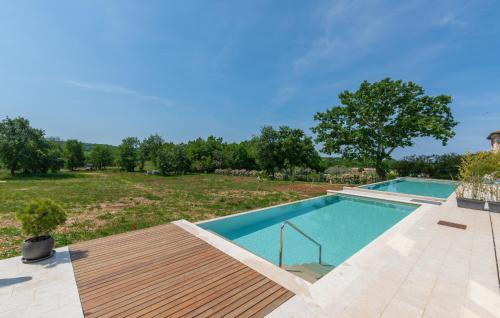 a swimming pool with a wooden deck and a yard at Green Zebra in Fuškulin