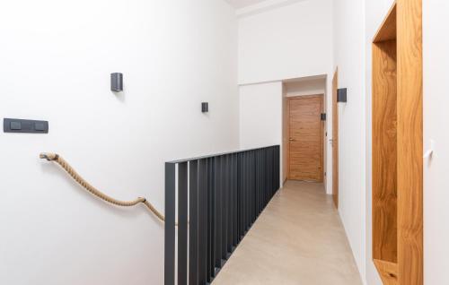 a hallway of a house with white walls and a black railing at Green Zebra in Fuškulin