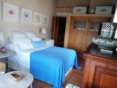 1 dormitorio con 1 cama con manta azul en Casa Bonita, en Mugardos
