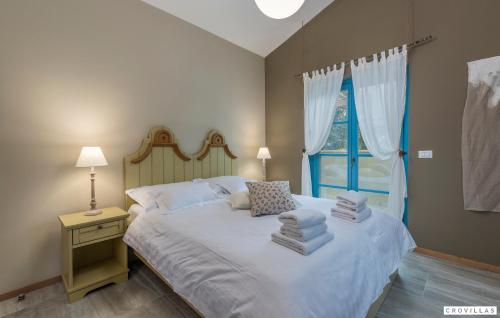a bedroom with a bed with white sheets and a window at Provence in Vilanija