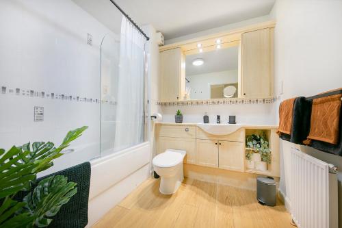 uma casa de banho com um WC e um espelho. em Links Road Apartment ✪ Grampian Lettings Ltd em Aberdeen