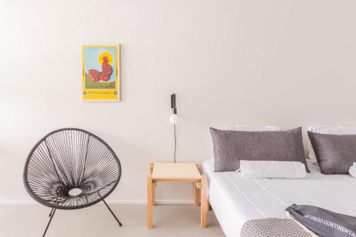 a living room with a couch and a fan at Tabas - Edifício União Continental in Sao Paulo