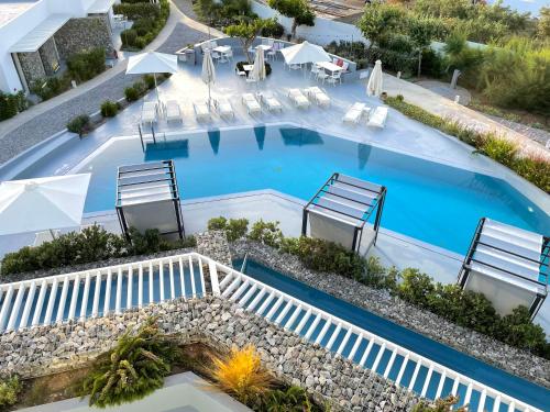 una vista aérea de una piscina con sillas y sombrillas en Relux Ios Hotel en Ios Chora