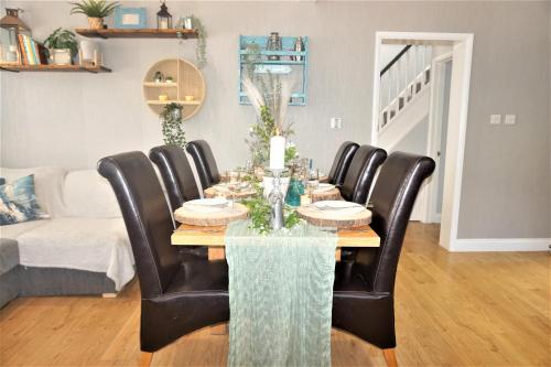 a dining room with a table and leather chairs at Lavender House, Fleet in Fleet