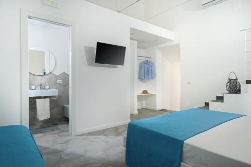 Cette chambre blanche comprend un lit et une salle de bains. dans l'établissement Casalulù Holiday Home - Lovely Apartment Sorrento Coast, à Vico Equense