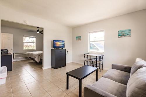 a living room with a couch and a table at Poolfront Cottage Near Beach with Full Kitchen! in Fort Myers
