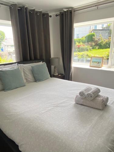 a bedroom with a large bed with towels on it at Heddfan - Peaceful Studio 5 mins from Stunning Llanbedrog Beach in Pwllheli