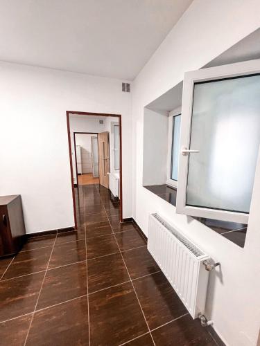 a hallway with white walls and a tile floor at 3 Apartments in 1 location in Prague