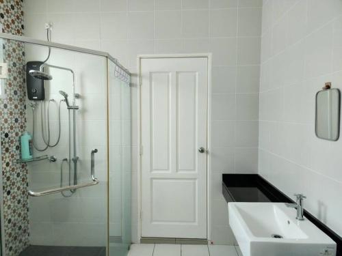 a white bathroom with a sink and a shower at Bandar Seri botani Ipoh luxury paris/17 pax/mahjong in Ipoh