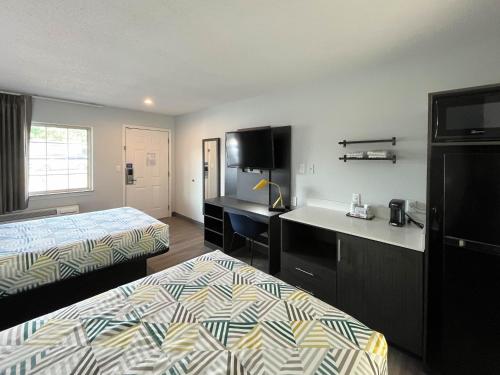 a hotel room with two beds and a desk at Suites Lafayette IN in Lafayette