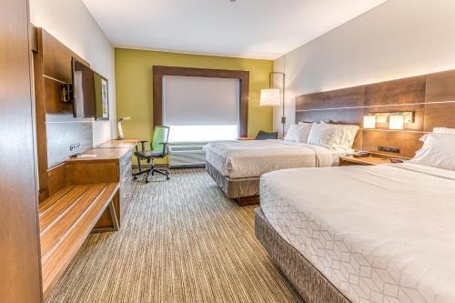 Habitación de hotel con 2 camas y escritorio en Holiday Inn Express & Suites - Rantoul, an IHG Hotel, en Rantoul