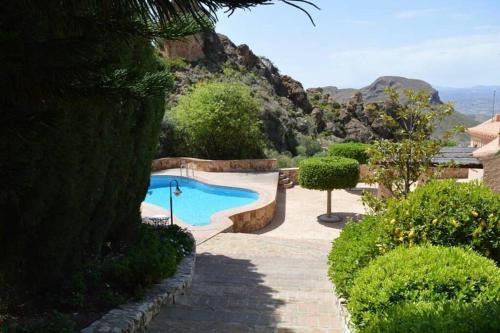 una piscina in un giardino con montagna di Casa Estrella a Almería