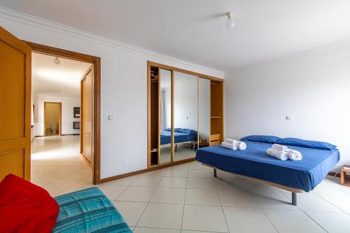 a bedroom with a blue bed and a mirror at Sky Mariposa sospesa sul mare in Mindelo