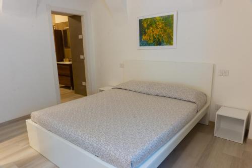 białe łóżko w sypialni z obrazem na ścianie w obiekcie Casa vacanza TORRE w mieście Pietramurata