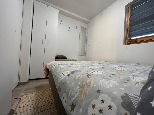 een slaapkamer met een bed met een dekbed erop bij Studio apartman Kod Ruže in Tuhelj