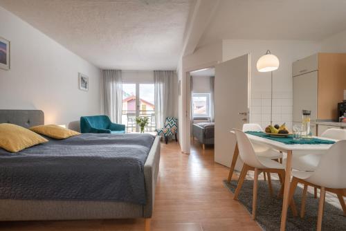 a bedroom with a bed and a table with chairs at Sun Valley Apartments in Maishofen