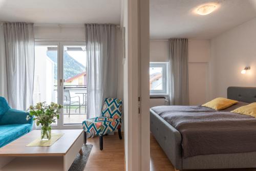 a bedroom with a bed and a living room at Sun Valley Apartments in Maishofen