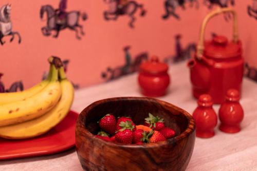 a wooden bowl of strawberries and bananas on a table at Haus Himmelfahrt in Soprabolzano