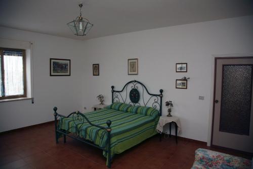 Schlafzimmer mit einem Bett mit grüner Bettwäsche in der Unterkunft Agriturismo Casalino dei Francesi in Montalto di Castro