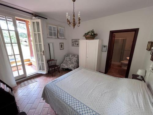 a bedroom with a bed and a chandelier at Tenuta Poggio alla Farnia in Fauglia