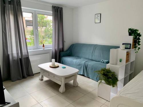 Sala de estar con sofá azul y mesa de centro en Ruhige Wohnung am Rande des Naturschutzgebietes en Ingelheim am Rhein