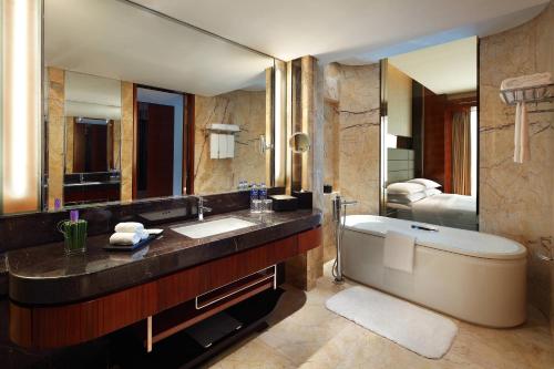 baño con bañera y espejo grande en Sheraton Hefei Xinzhan Hotel, en Hefei