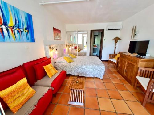 salon z łóżkiem i czerwoną kanapą w obiekcie Villa Ti Paradis w mieście Saint-François