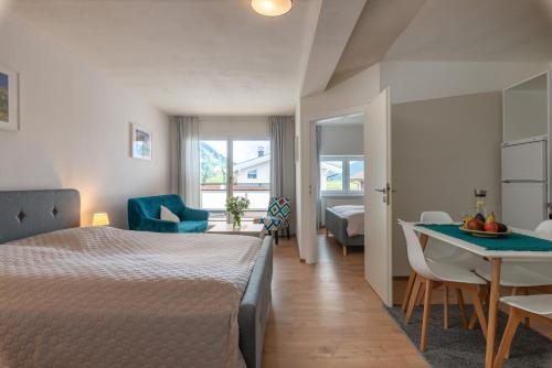 a bedroom with a bed and a table in a room at Sun Valley Apartments in Maishofen