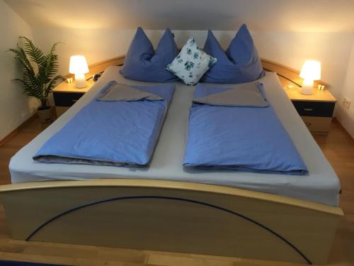 ein großes Bett mit blauen Kissen darüber in der Unterkunft Apartment Eichwald in Sexau