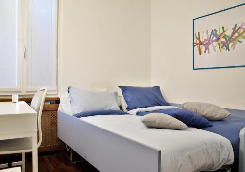 Un dormitorio con una cama con almohadas azules. en Casa del Vicolo, nel cuore della Pavia storica, en Pavia