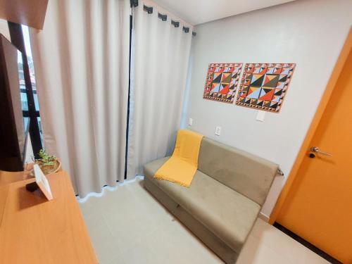 a living room with a couch and a yellow pillow at Maraca Beach Residence II - Porto de Galinhas in Porto De Galinhas