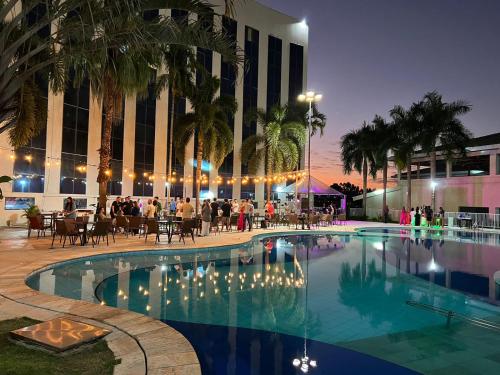 a pool at a hotel with people sitting around it at Condominio Barretos Thermas Park - Condohotel 1242 in Barretos