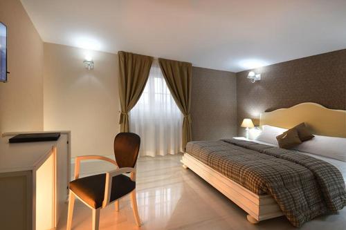 a bedroom with a bed and a chair and a window at Villa Minieri Resort & SPA in Nola