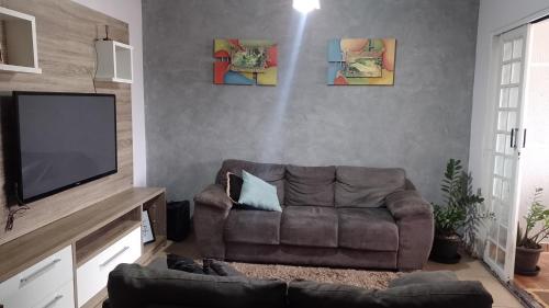 a living room with a couch and a flat screen tv at Casa Gil in Foz do Iguaçu