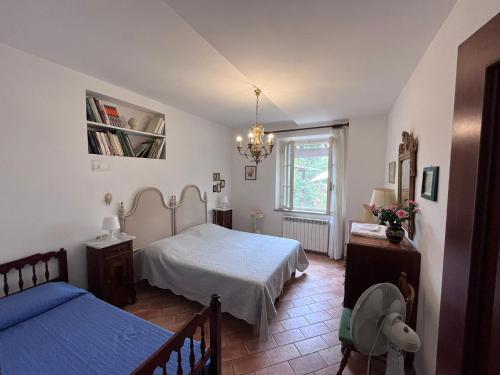 1 dormitorio con 2 camas y lámpara de araña en Tenuta Poggio alla Farnia, en Fauglia